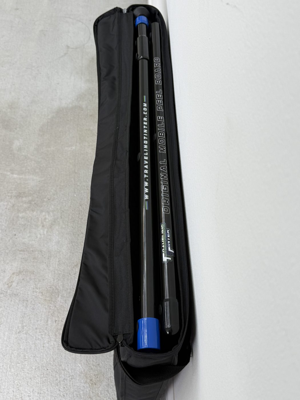 The board sliding into its black carry bag