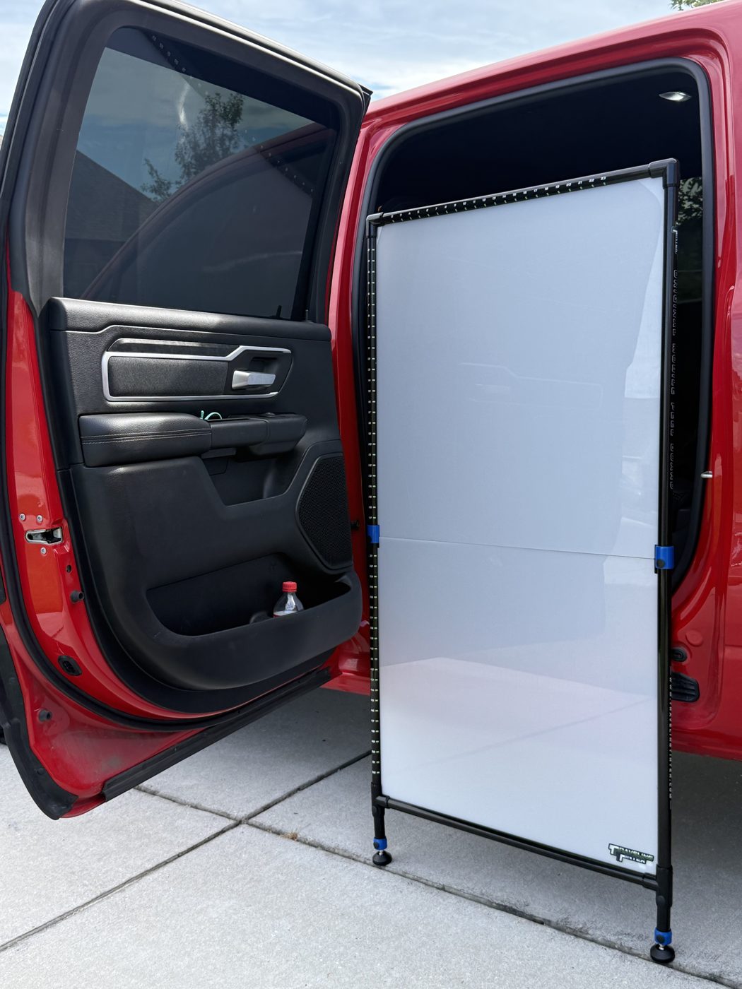 The peel board set up next to the open doors of a red pickup